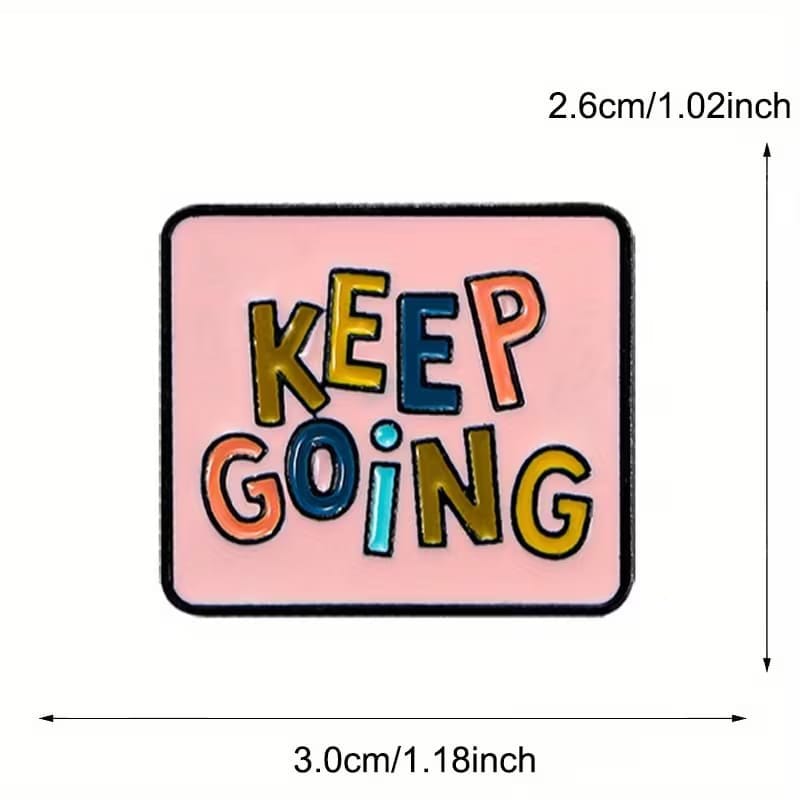 Keep Going enamel pin styled on a blue fabric bag