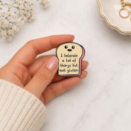 Gluten free enamel pin smiling bread slice kawaii funny lapel pin held in hand marble background