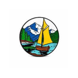 Travel enamel pin featuring sailboat, mountain landscape and lake round metal badge