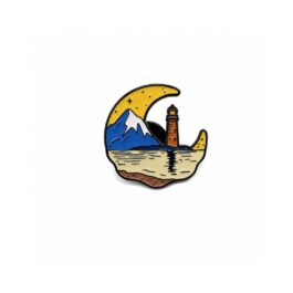 Travel enamel pin featuring lighthouse, mountain landscape and crescent moon design