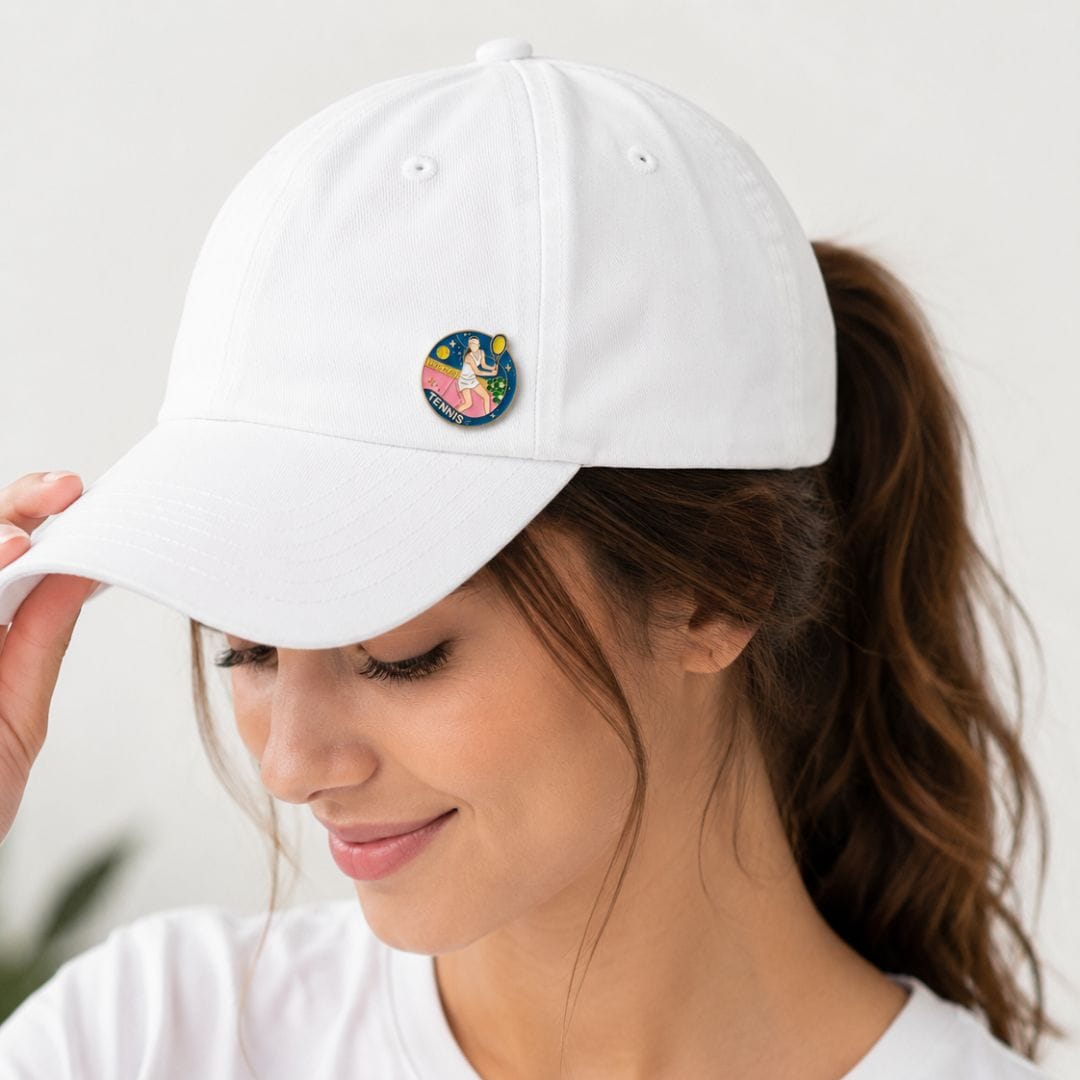 Close-up of tennis enamel pin showing raised gold outlines and hard enamel colour fills