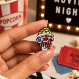 Movie night popcorn enamel pin with 3D glasses held in hand