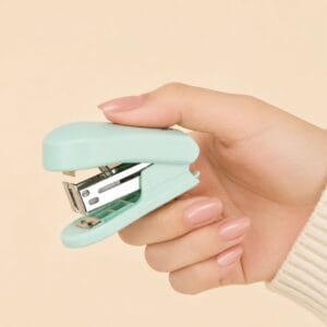 Mini teal stapler with a strong metal stapling mechanism designed for everyday paperwork assignments planners notebooks journals and creative craft projects.