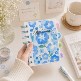 Blue floral spiral notebook with colorful tabbed dividers and decorative cover