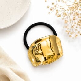 Gold tone hammered metal hair tie with black elastic